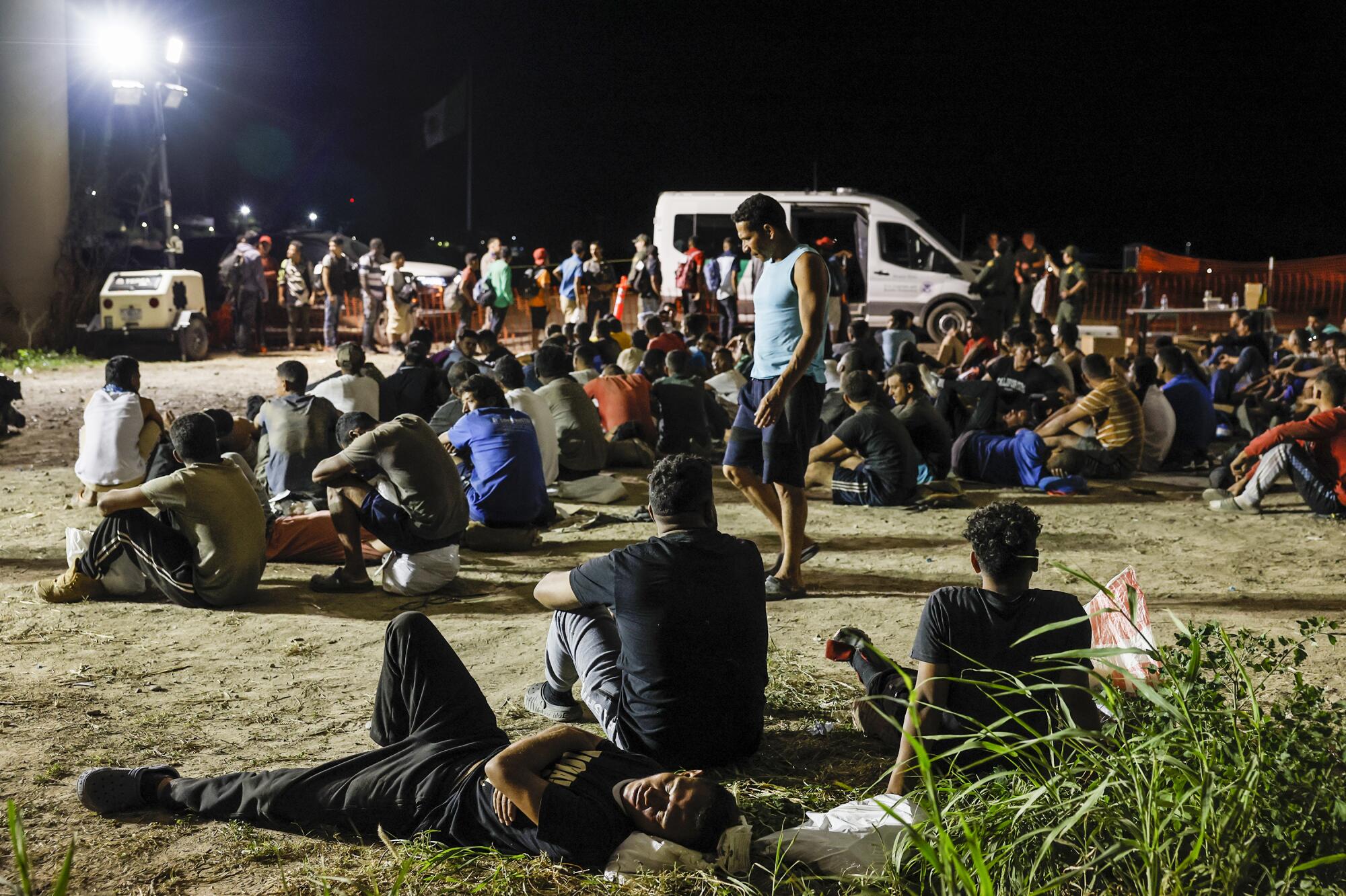 Hundreds of migrant men wait to be transported by US Border Patrol from a holding area near the Rio Grande