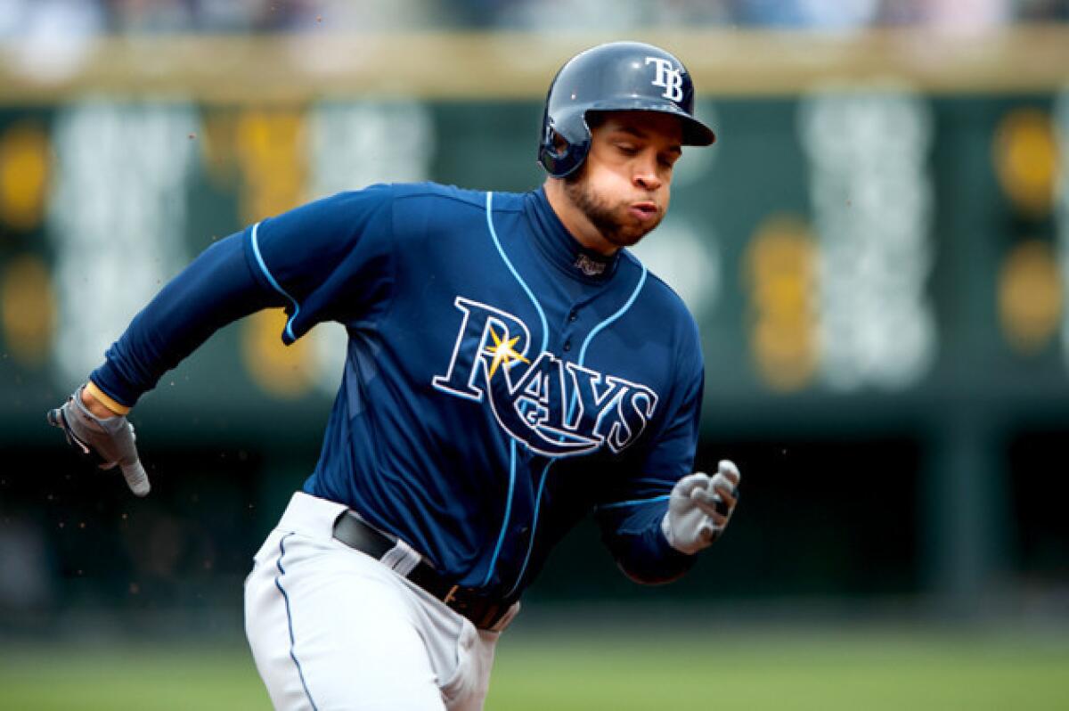 Tampa Bay Rays' James Loney rounds third base on his way to score a run against the Colorado Rockies.