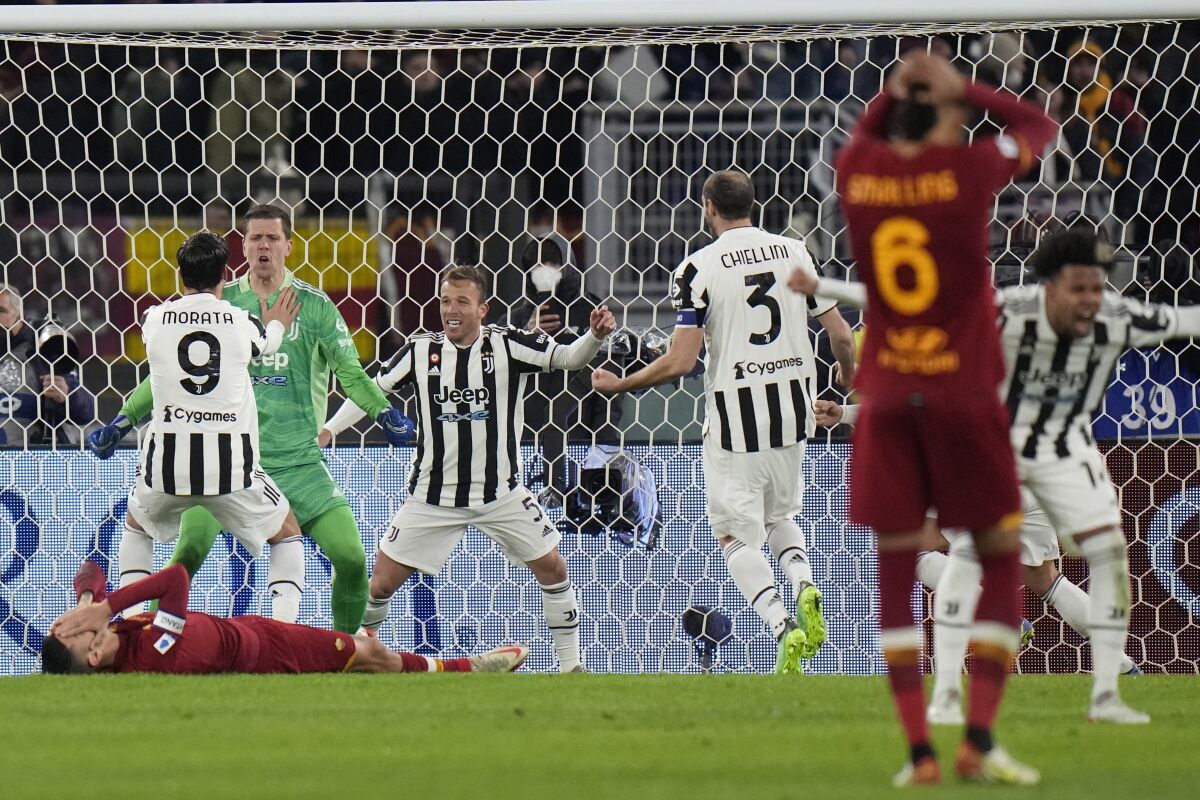 Juventus' goalkeeper Wojciech Szczesny, second left, celebrates with his teammates after saving a penalty shot by Roma's Lorenzo Pellegrini, bottom, during the Italian Serie A soccer match between Roma and Juventus at the Olympic stadium in Rome, Italy, Sunday, Jan. 9, 2022. (AP Photo/Alessandra Tarantino)