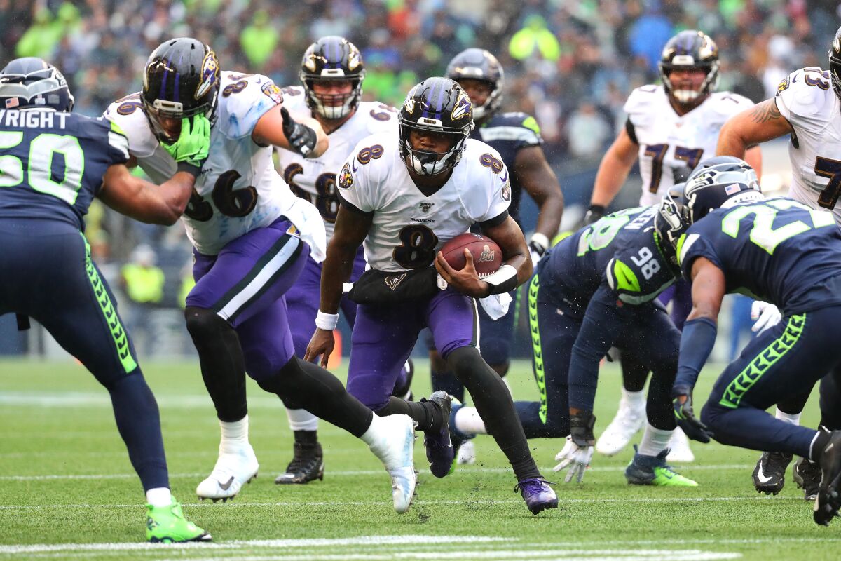Baltimore Ravens quarterback Lamar Jackson runs with the ball against the Seattle Seahawks during the third quarter.