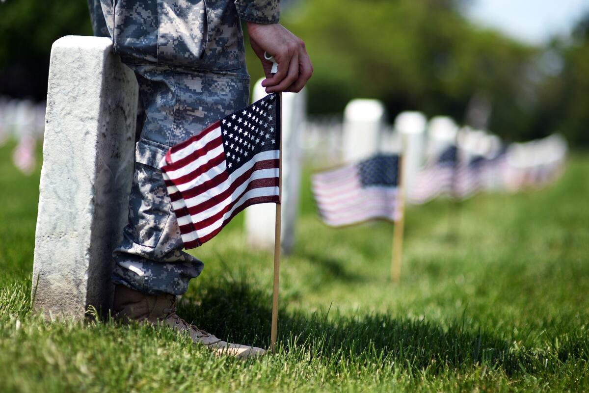 A solider places a flag at Arlington National Cemetery ahead of Memorial Day.