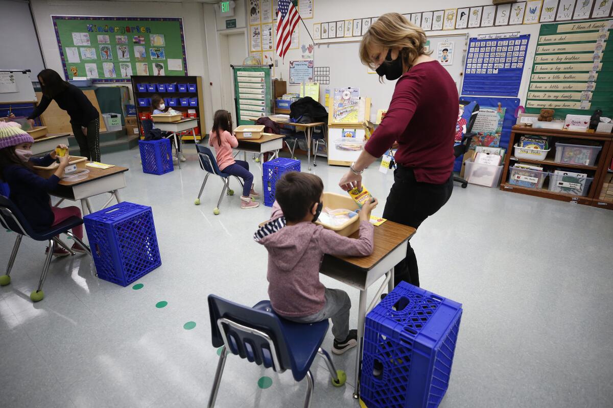 Kindergarten teacher Jennifer Klein collects crayons from students at Lupin Hill Elementary.
