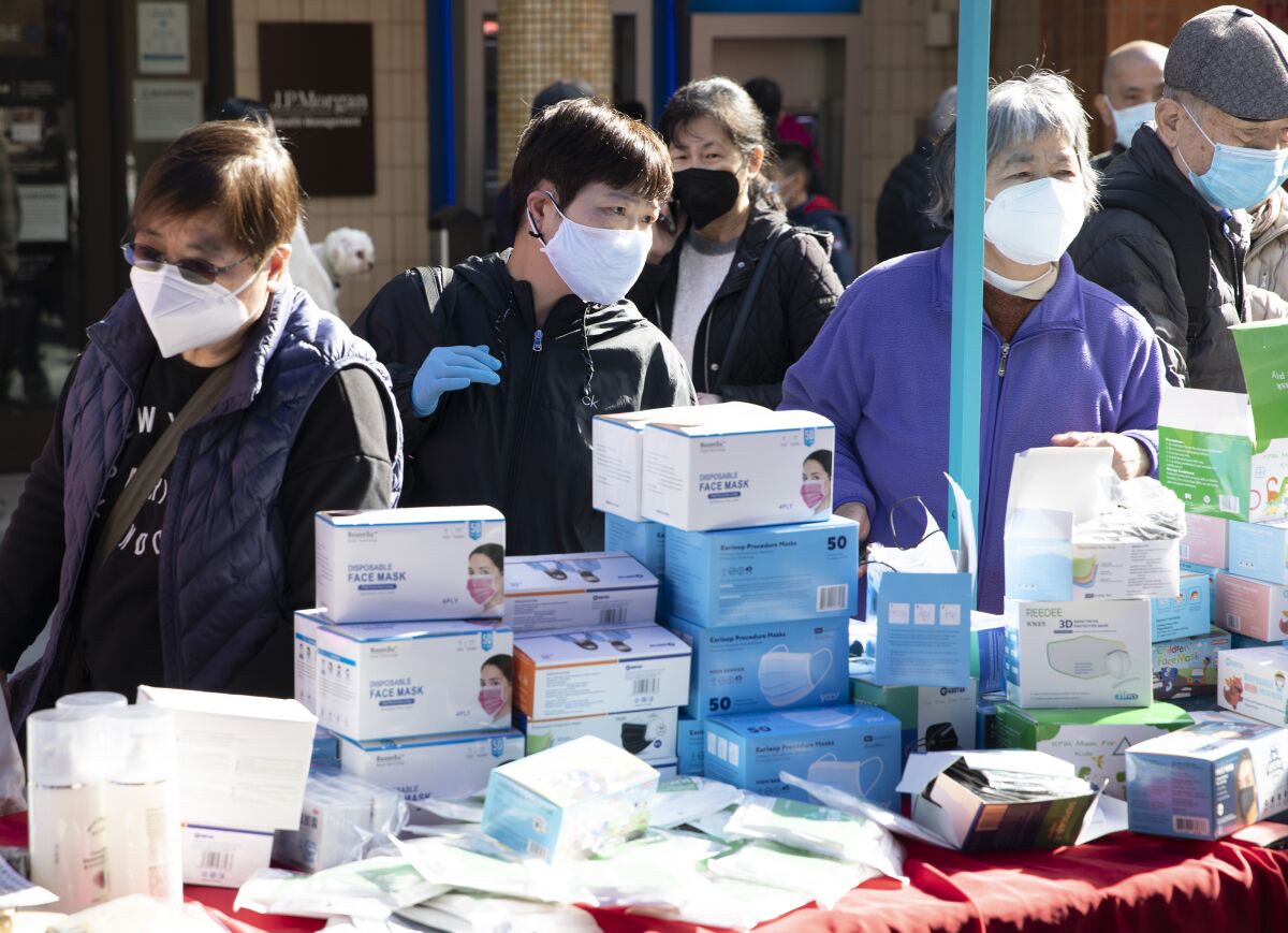 Customers shop for disposable masks at the Chinese New Year Flower Market Fair in Chinatown in San Francisco
