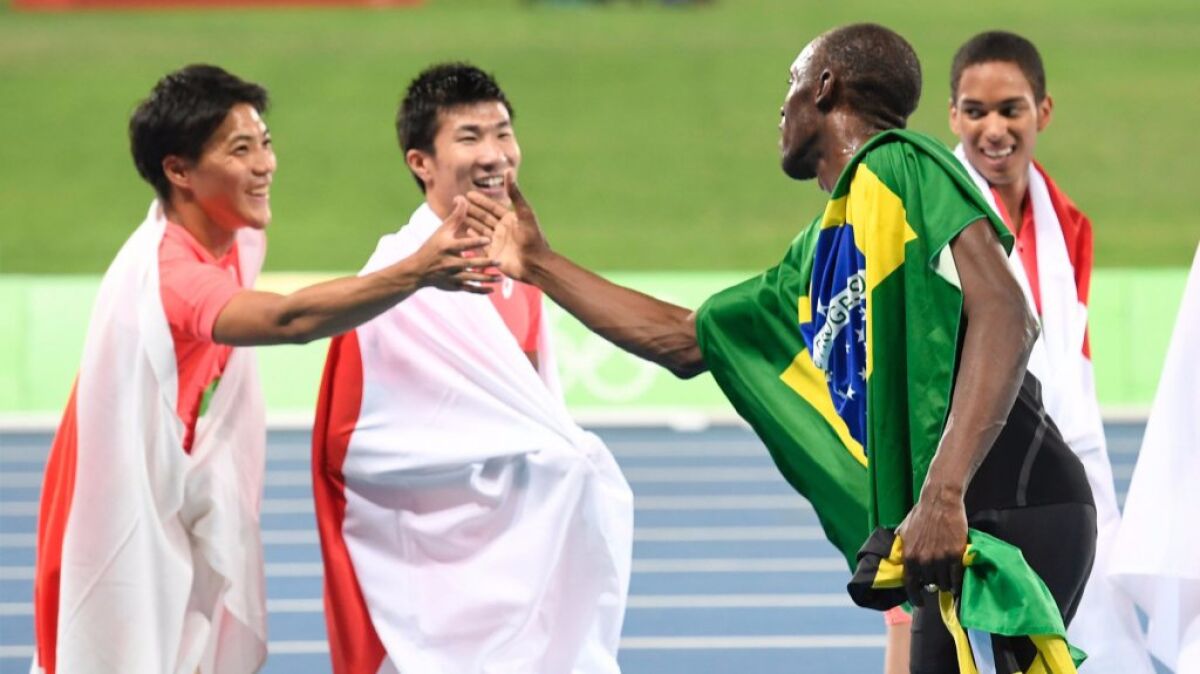 Jamaican sprinter Usain Bolt, right, shakes hands with Japanese runners on Aug. 19 at the Olympic Games in Rio de Janeiro. A new study finds surprising shared sound patterns across unrelated languages around the world.