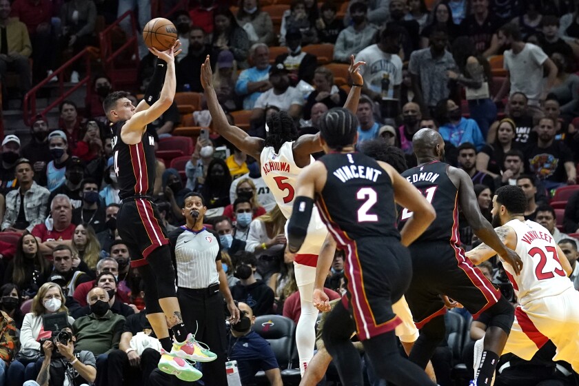 Miami Heat guard Tyler Herro, left, shoots over Toronto Raptors forward Precious Achiuwa (5) during the first half of an NBA basketball game, Monday, Jan. 17, 2022, in Miami. (AP Photo/Lynne Sladky)