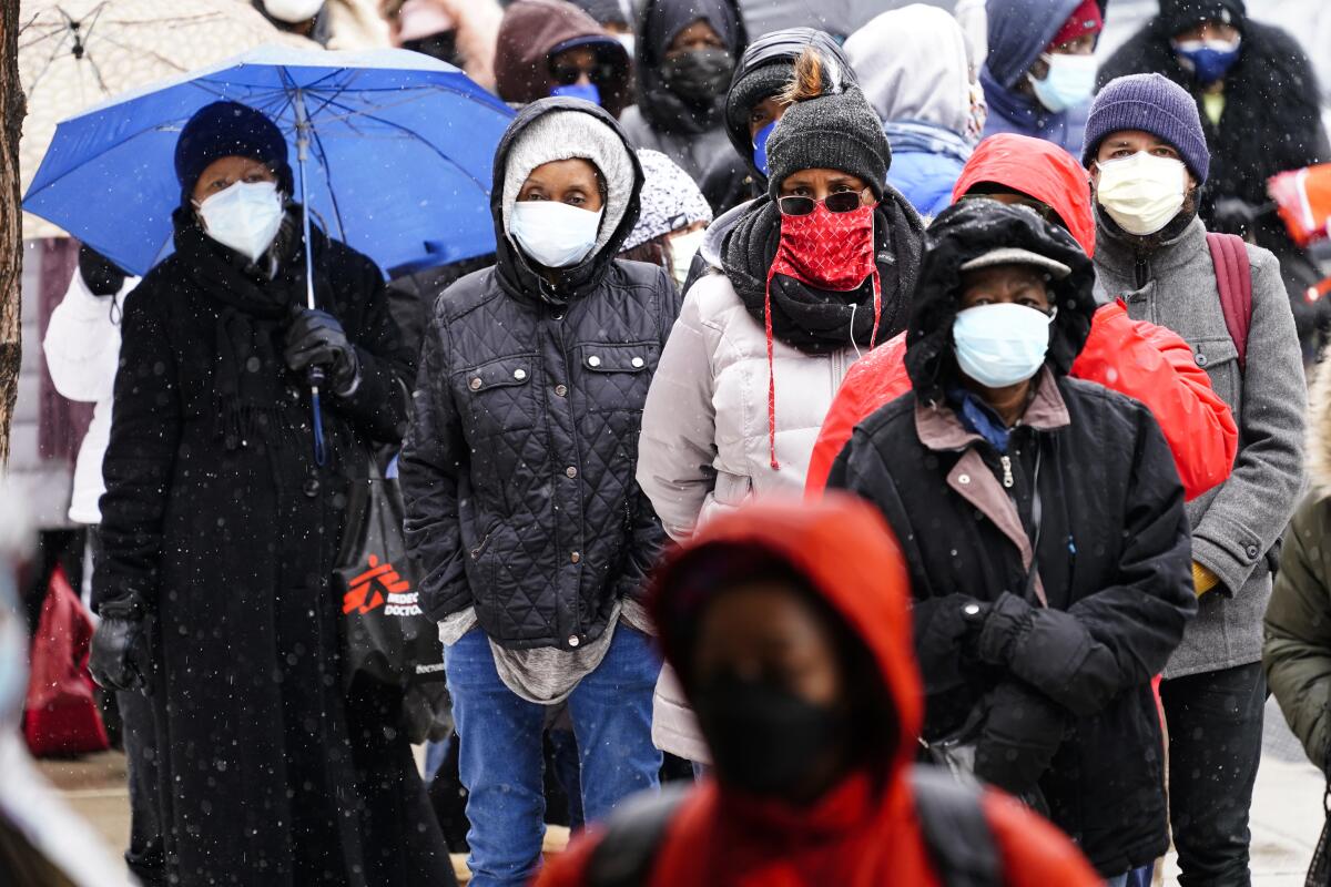 ARCHIVO - En esta foto del 19 de febrero del 2021, personas esperan en fila en una clínica de vacunación 