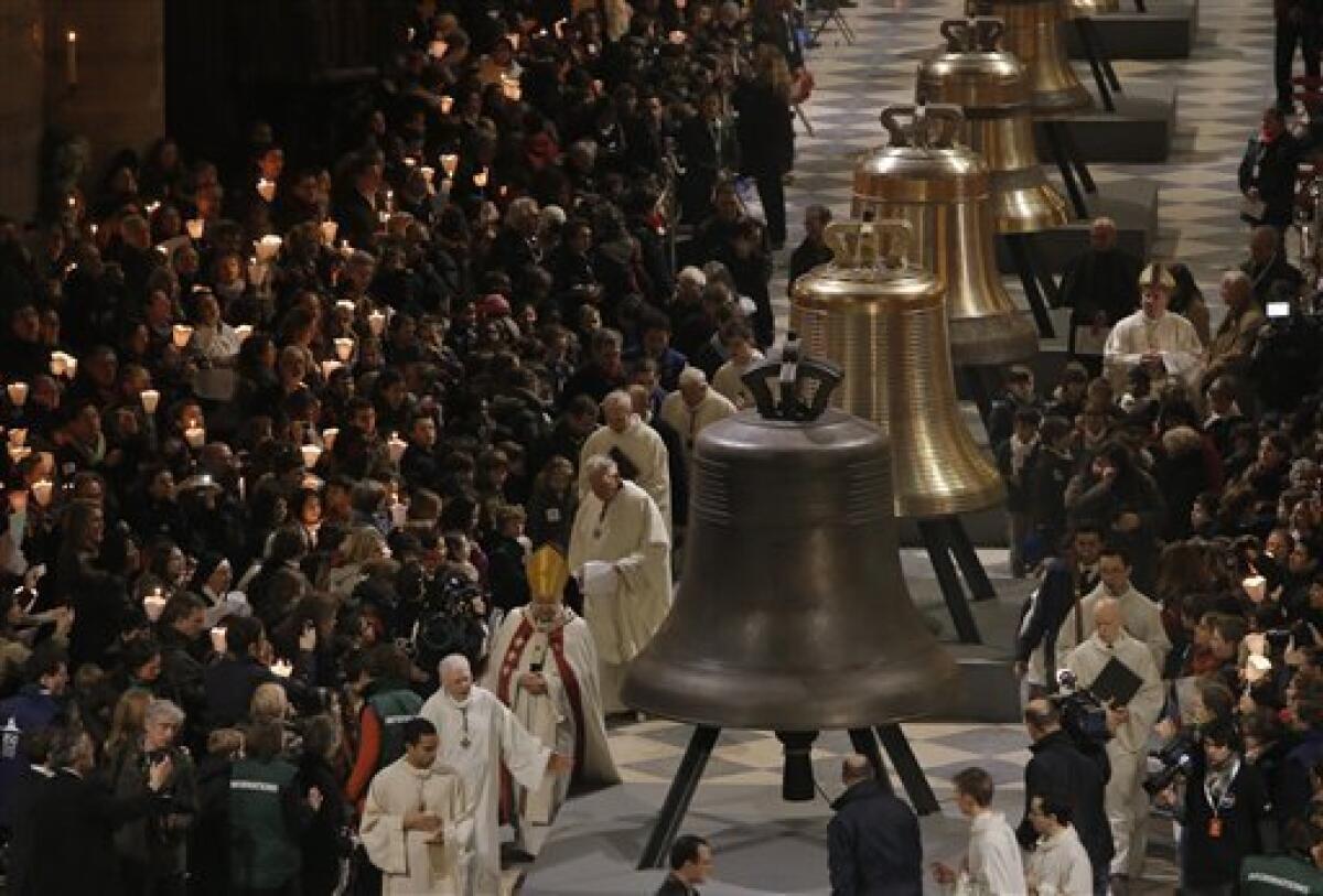 Some of the nine new bronze bells are displayed in Notre Dame cathedral during a ceremony of blessing by Paris Archbishop Andre Vingt-Trois in Paris, Saturday, Feb. 1, 2013. Nine enormous new bronze bells have made their way at Notre Dame Cathedral, helping the medieval edifice to rediscover its historical harmony. (AP Photo/Francois Mori)