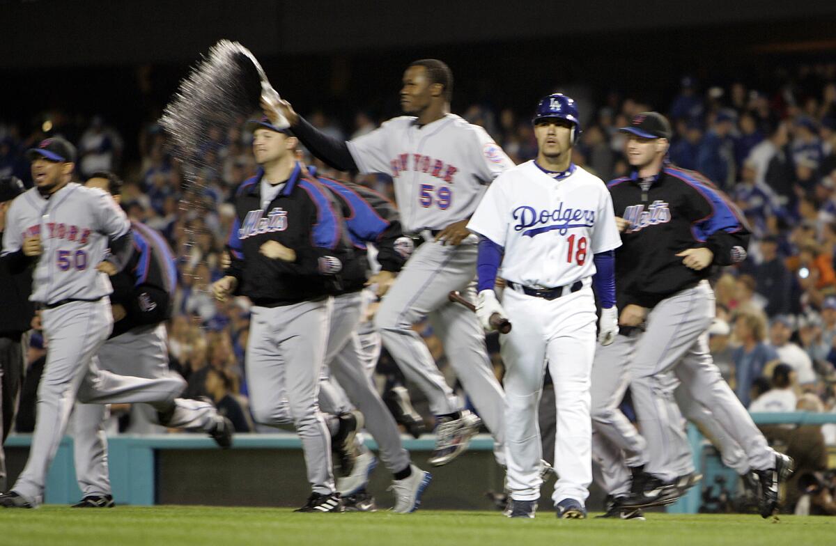 Dodgers batter Ramon Martinez walks off the field as the New York Mets celebrate their 2006 NLDS win.