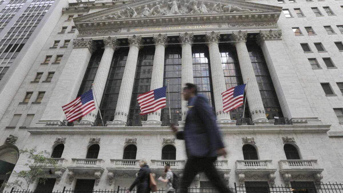 People walk past the New York Stock Exchange in June 2016.