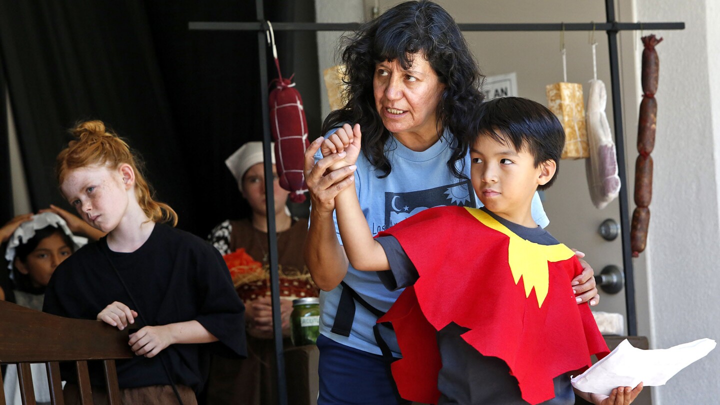 Alejandra Flores, center, gives directions in Spanish to Camilo Choi, right, as Stella Ferguson, left, listens during a one-week Spanish-only theater camp at Elysian Park.