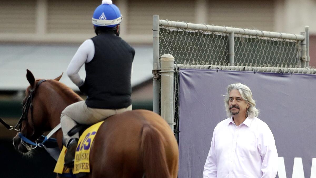 Trainer Steve Asmussen chats with exercise rider Angel Garcia Thursday during a morning workout for Gun Runner at Del Mar.
