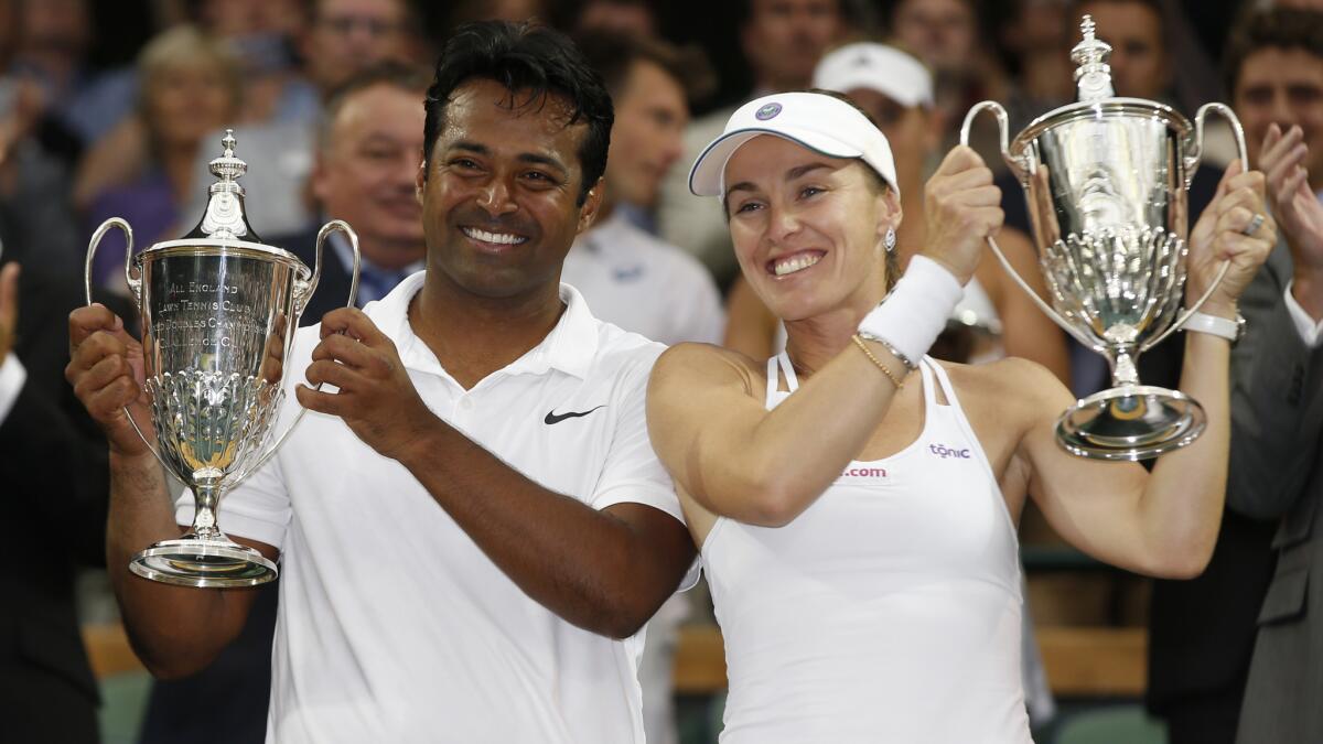 Leander Paes, left, and Martina Hingis celebrate their mixed doubles championship victory at Wimbledon on Sunday.