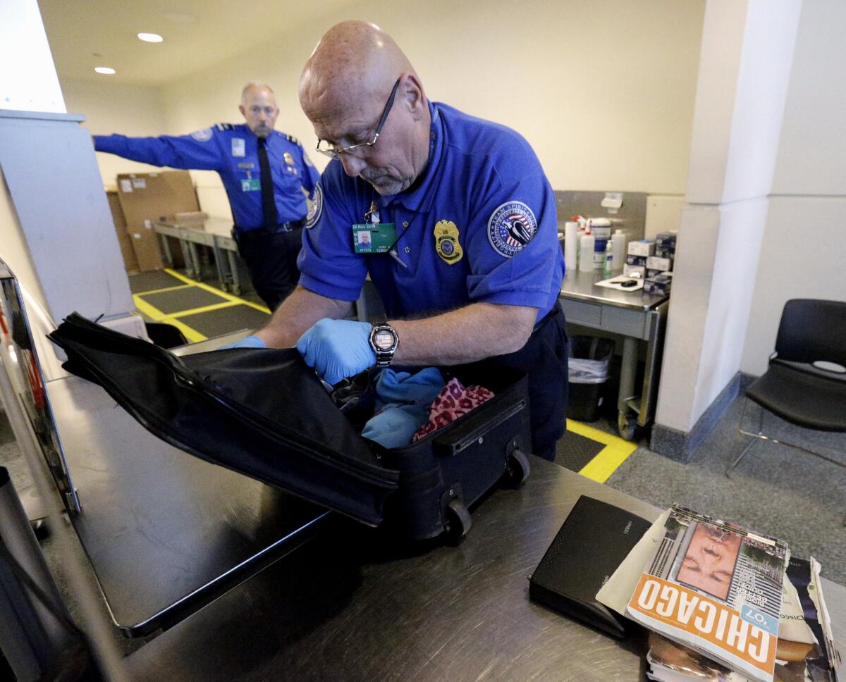 A TSA agent checks a bag at Midway International Airport in Chicago.