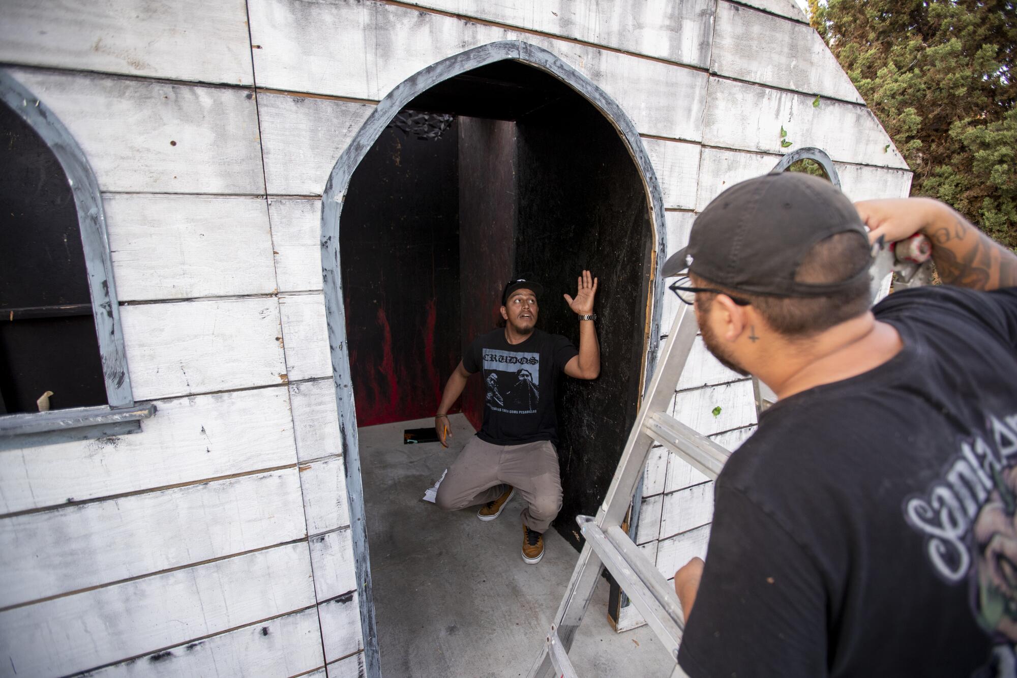 Two men discuss plans for halloween haunted house called Santa Ana Haunt at Garcia's father's home in Santa Ana.