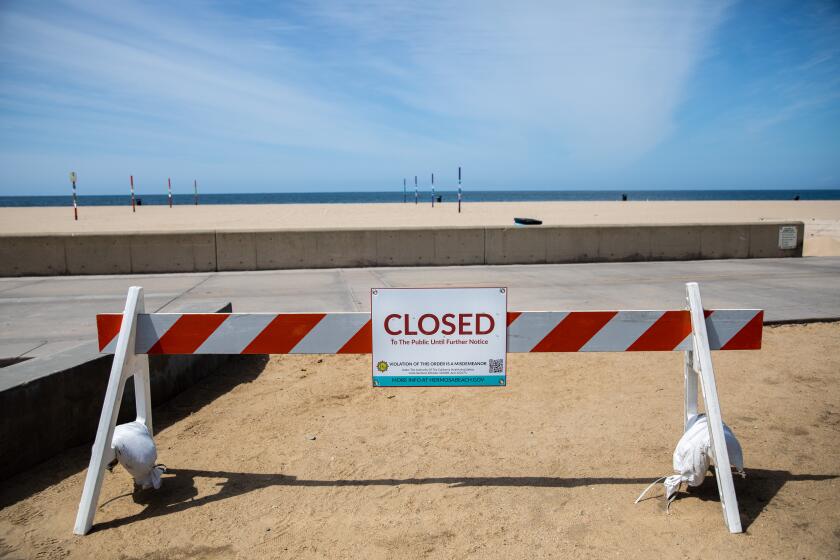 HERMOSA BEACH, CA --MARCH 28, 2020 - Signs and barricades let people know of the closures of The Strand and the beach in Hermosa Beach, CA., as part of Los Angeles County's closures, in an effort to prevent crowds and gatherings of people and slow the spread of the coronavirus, March 28, 2020. (Jay L. Clendenin / Los Angeles Times)