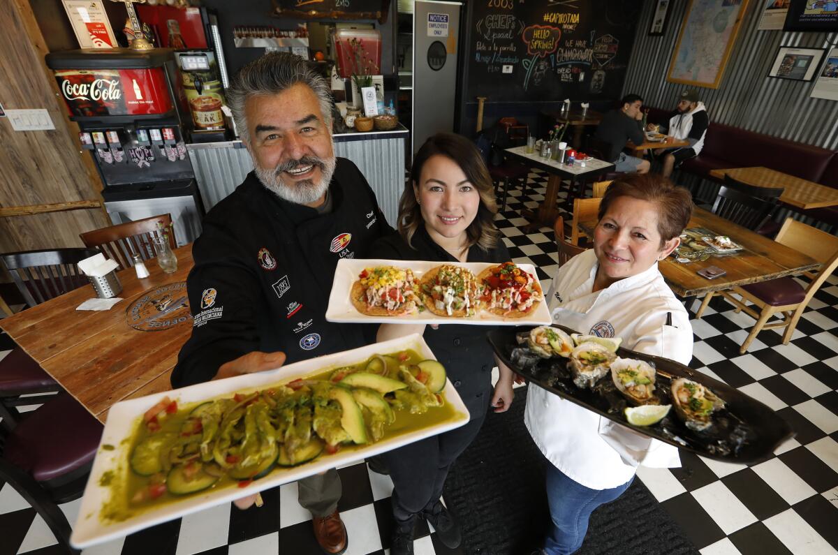 Executive chef Natalie Curie, center, with her parents, Leonardo and Maria Curie, founders of the restaurant.