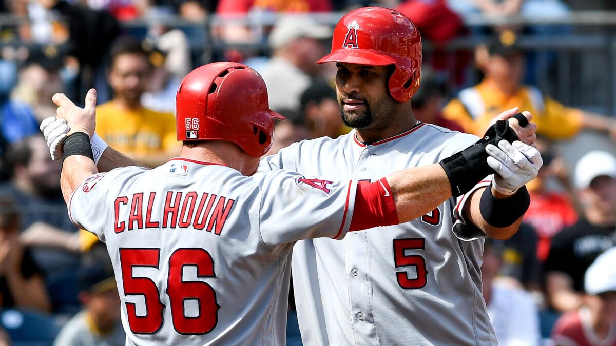 Angels first baseman Albert Pujols (5) is congratulated by teammate Kole Calhoun after hitting a two-run home run against the Pirates in the eighth inning Sunday.