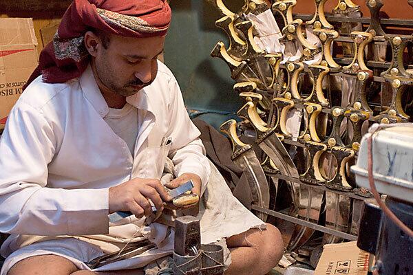 A craftsman carves the hilt of a jambiya