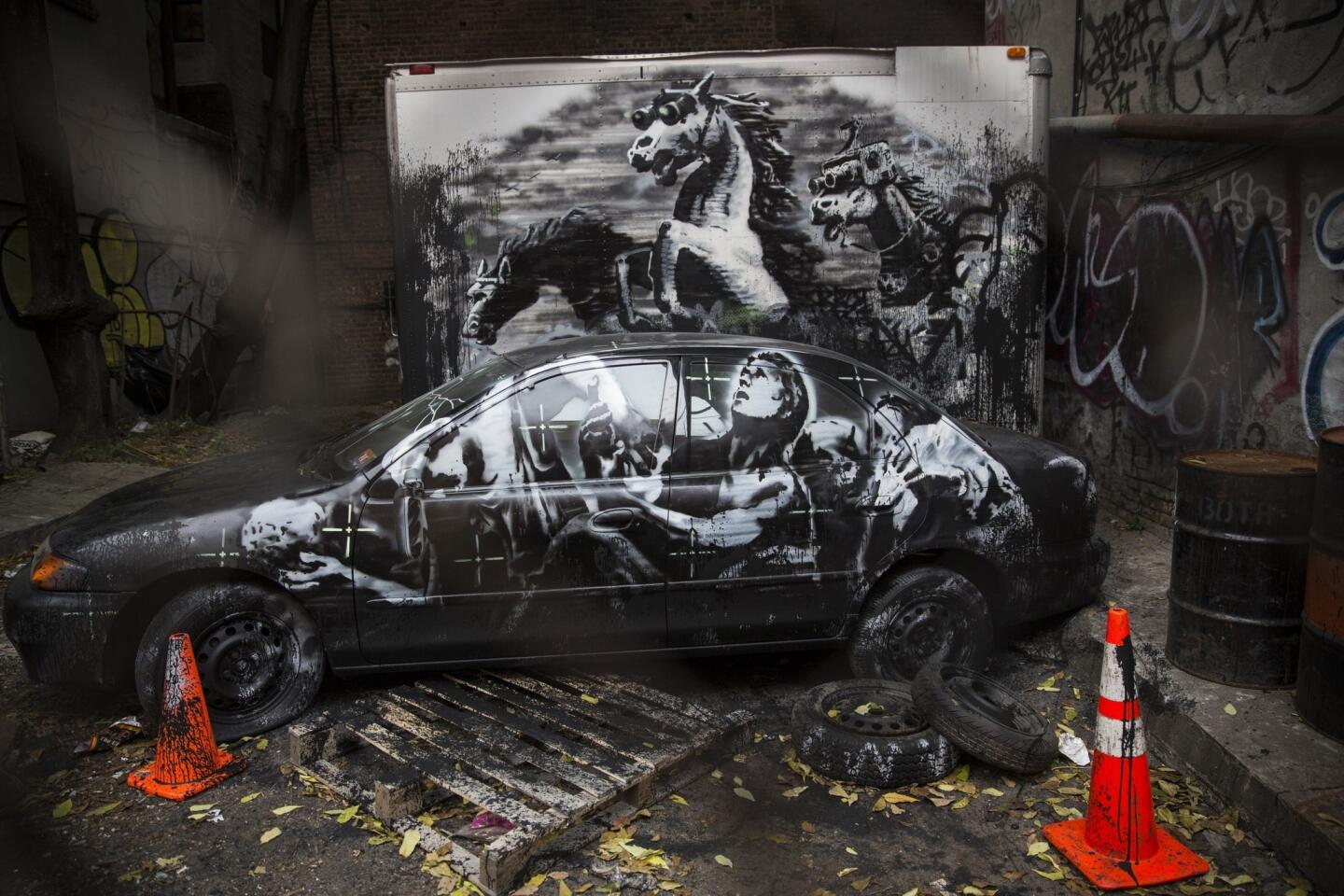 Seen through a fence in New York City, Banksy's trio of stampeding horses wear night-vision goggles while a group of men kneel before them. A tape recording of a 2007 U.S. airstrike plays in the background, revealing the killing of two children and a Reuters journalist.