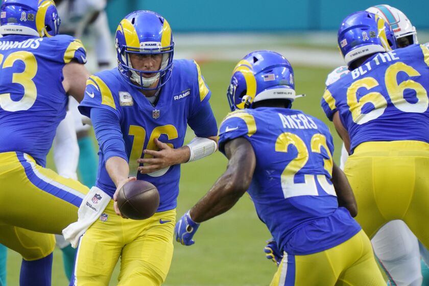 Los Angeles Rams quarterback Jared Goff (16) hands the ball to running back Cam Akers (23), during the second half of an NFL football game against the Los Angeles Rams, Sunday, Nov. 1, 2020, in Miami Gardens, Fla. (AP Photo/Wilfredo Lee)