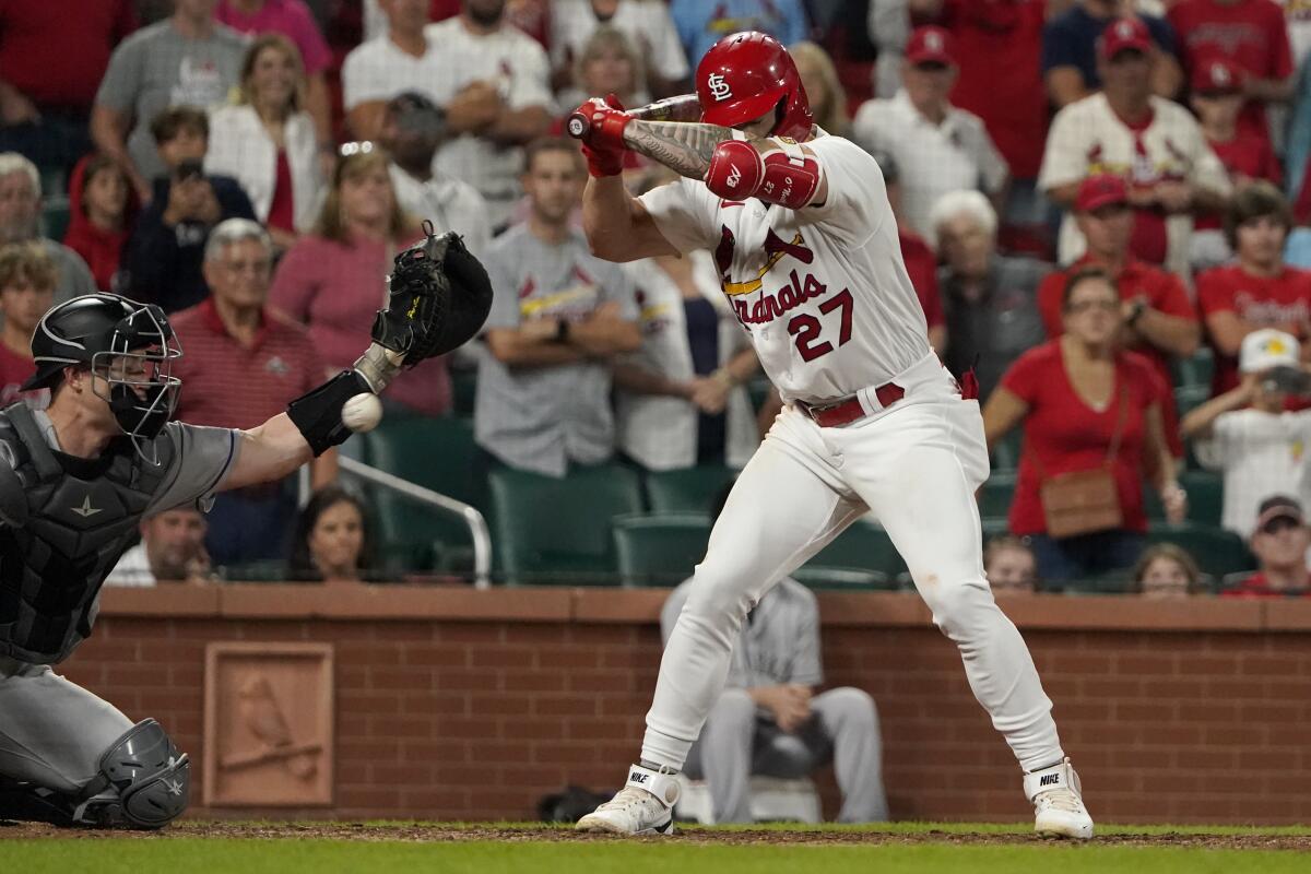 Colorado Rockies catcher Brian Serven, left, reaches for the ball after St. Louis Cardinals' Tyler O'Neill (27) was hit by a pitch with the bases loaded to score Andrew Knizner ending a baseball game Tuesday, Aug. 16, 2022, in St. Louis. The Cardinals won 5-4. (AP Photo/Jeff Roberson)
