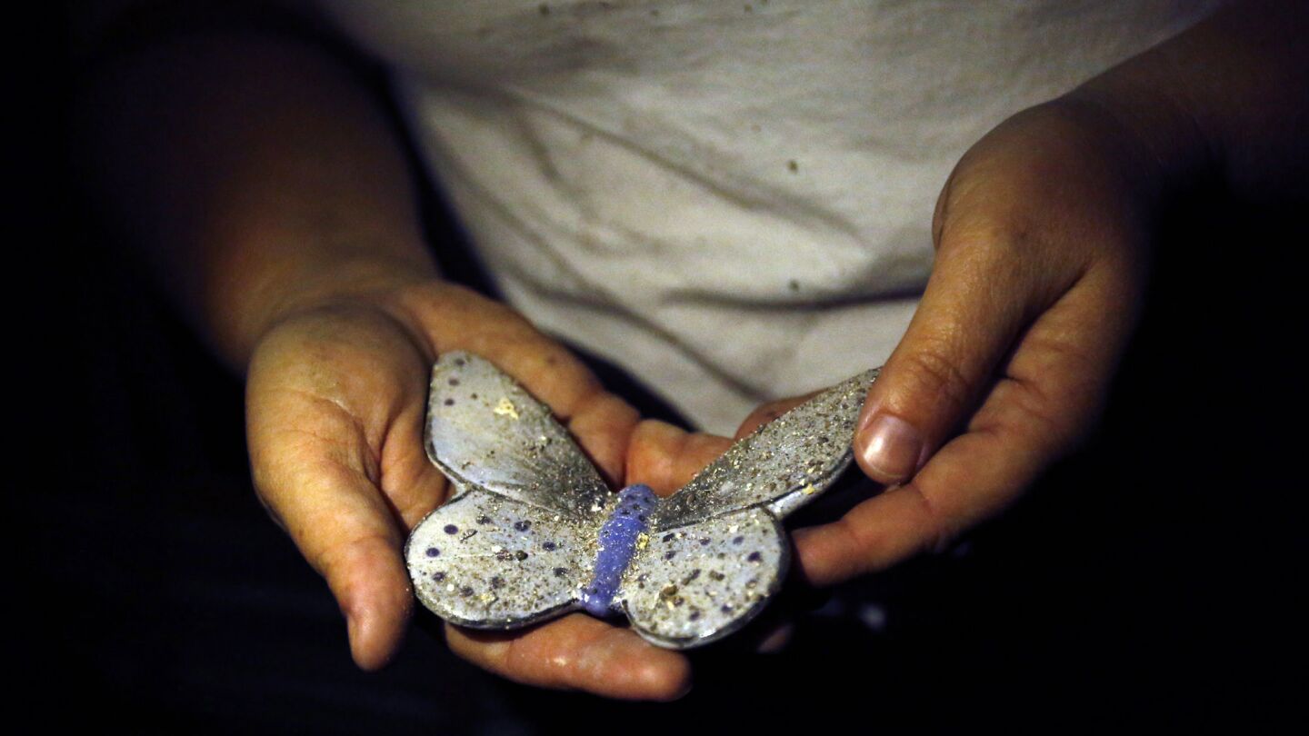 Kimberly Flinn holds onto the only item that wasn't lost in a fire that destroyed her home in the Mark West Springs area in Santa Rosa. Flynn recovered a ceramic white butterfly that she had made in memory of a boy she used to babysit and was killed in a hit and run accident.