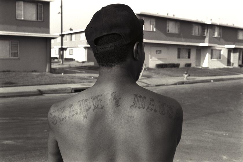 An OG or "original gangster" member of the Grape Street Crips shows off his tattoo. The Grape Street Watts Crips are a mostly African American street gang based in the Jordan Downs housing project in Watts. Their main enemies are the Bounty Hunter Bloods who are based in the neighboring Nickerson Gardens neighborhood, although their rivalry has ebbed since the gang truce following the 1992 Los Angeles riots. (Photo by Axel Koester/Corbis via Getty Images)