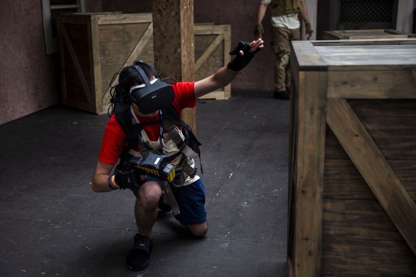 A participant in the Amazon Prime Jack Ryan activation ducks to avoid enemy combatants in a VR simulation.