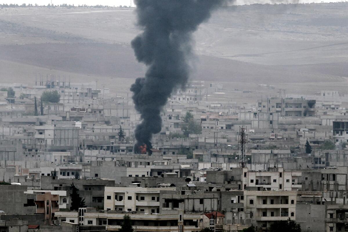 Smoke rises above buildings after Islamic State militants hit Syrian town of Kobani with a mortar fire on October 19, 2014.
