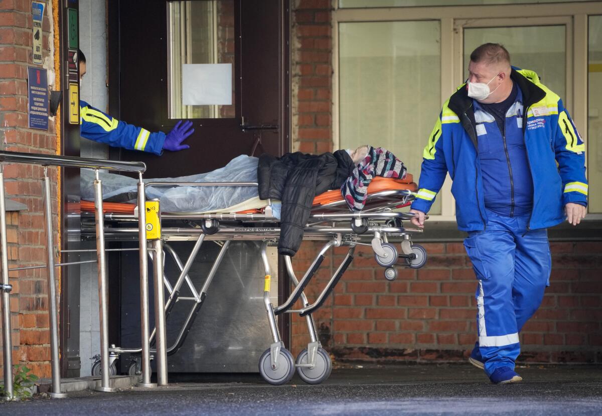 Medical workers in Russia transport a patient suspected of having COVID-19 on a stretcher.