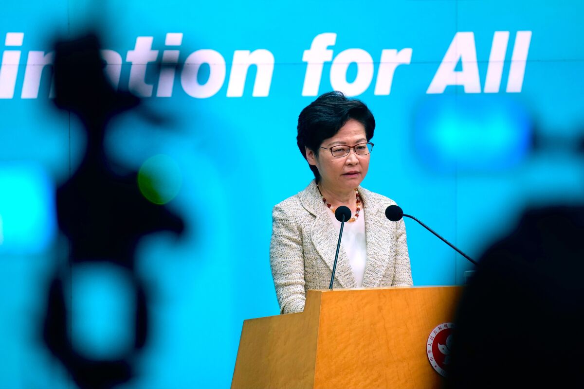 Hong Kong Chief Executive Carrie Lam listens to reporters' questions during a press conference in Hong Kong, Tuesday, July 13, 2021. Lam said that authorities will press on with the oath-taking requirement for district councilors to pledge allegiance to Hong Kong, despite an exodus over the last week. (AP Photo/Vincent Yu)