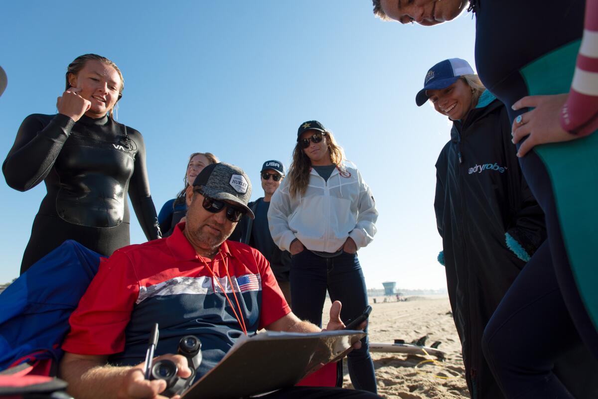 USA Surfing junior team head coach Ryan Simmons (bottom left) goes over training notes.