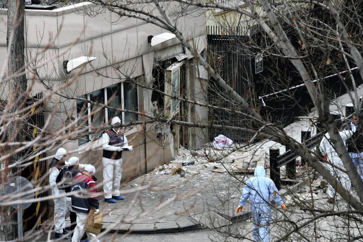 Investigators inspect the scene of the bombing at the U.S. Embassy in Ankara, Turkey. Among the injured was a Turkish television journalist who was visiting the American ambassador.