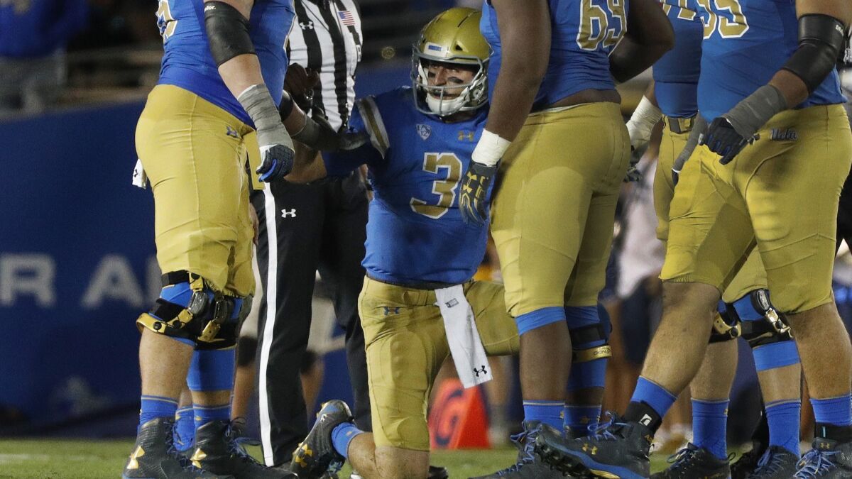 UCLA quarterback Josh Rosen is helped up by teammates after a hard sack in the second quarter against California on Nov. 24, 2017.
