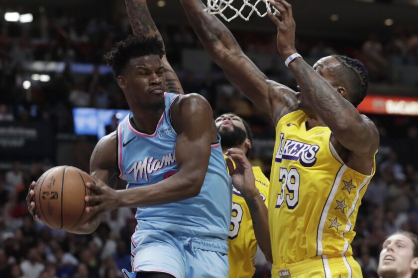 Miami's Jimmy Butler looks to pass after driving against Lakers defenders Dwight Howard (39) and Anthony Davis.