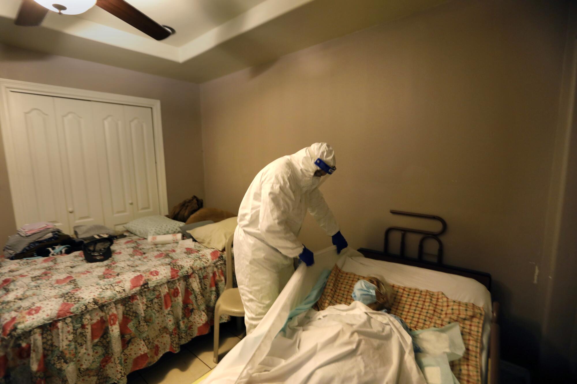 Juan Lopez prepares to remove the body of 91 year-old Amalia Tinoco from her home in Pharr, Texas.