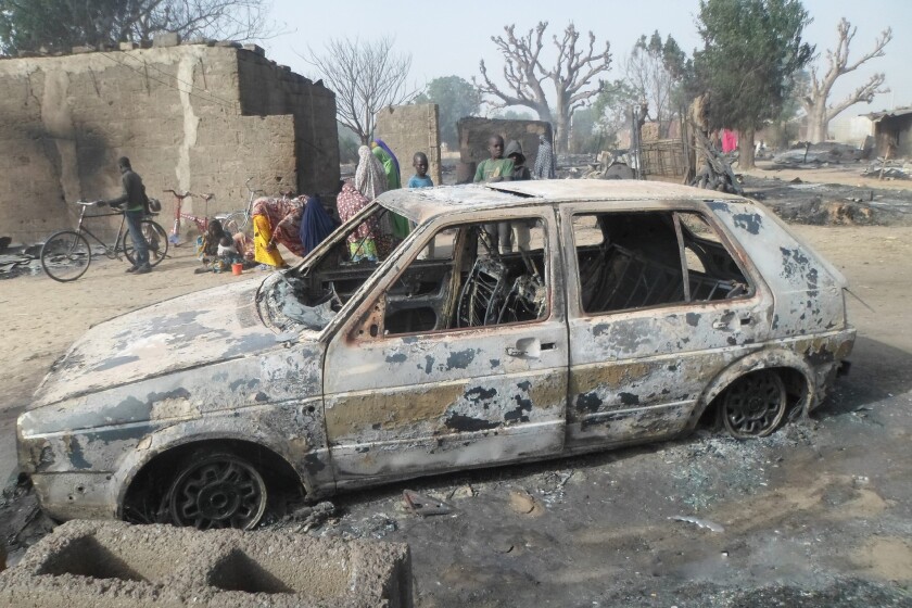 Children gather around a burnt-out car Sunday after an attack by Boko Haram in Dalori village, Nigeria.