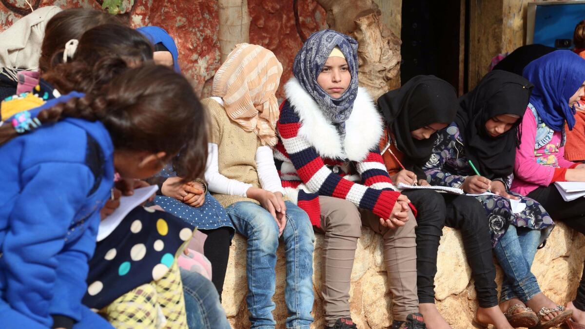 Syrian children who lost their parents in the country's civil war sit outside an orphanage near the town of Sarmada.