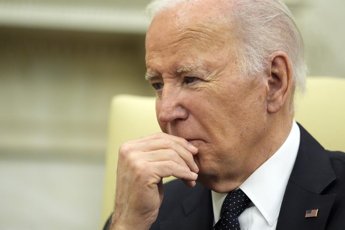 President Biden listens during a meeting in the Oval Office.