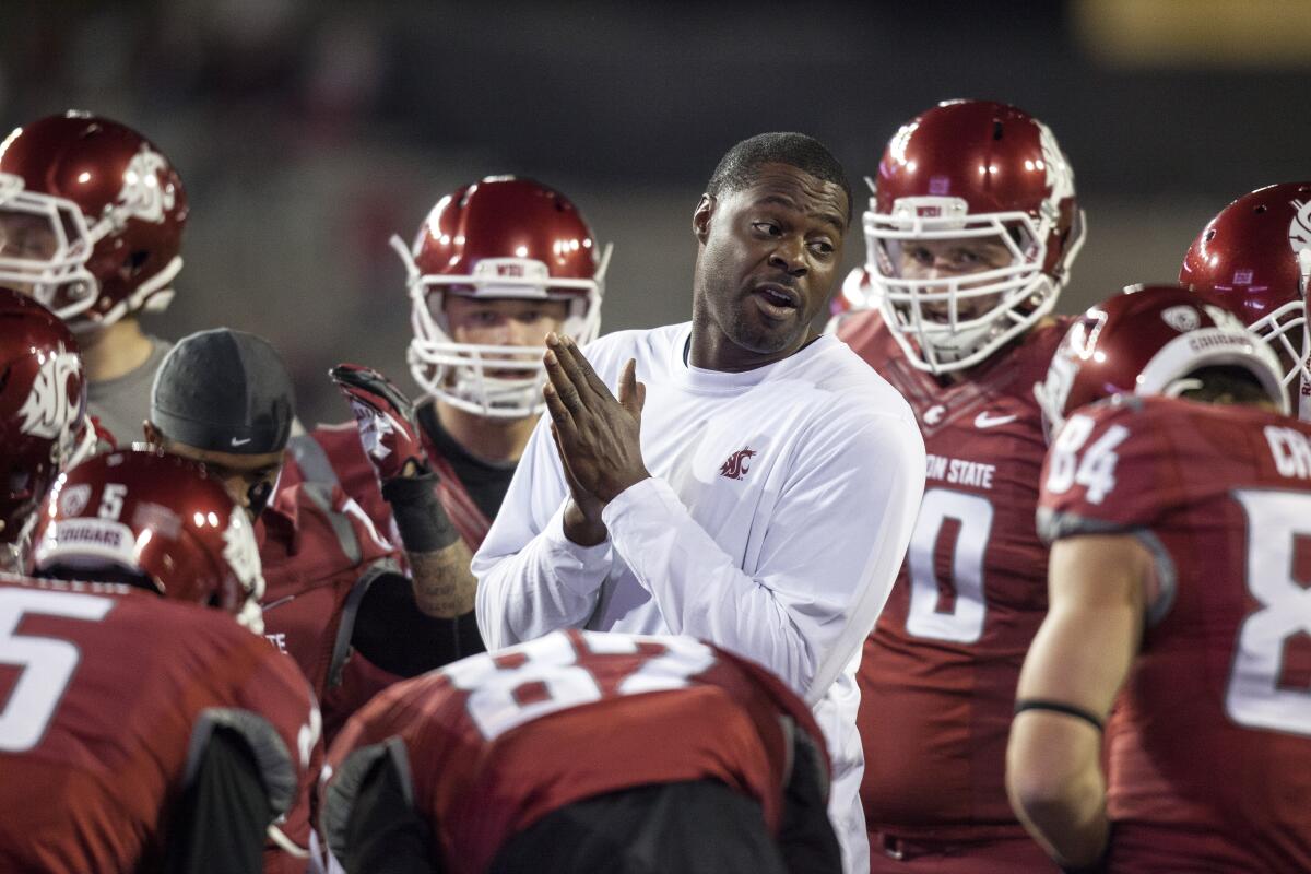 Washington State outside receivers coach Dennis Simmons talks to the offense.
