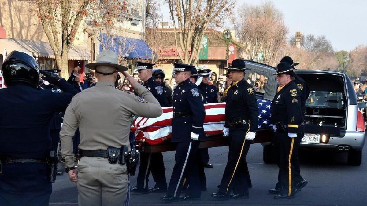 Law enforcement officials carry the casket of police Cpl. Ronil Singh into the Westside Theatre for a public viewing in Newman, Calif.