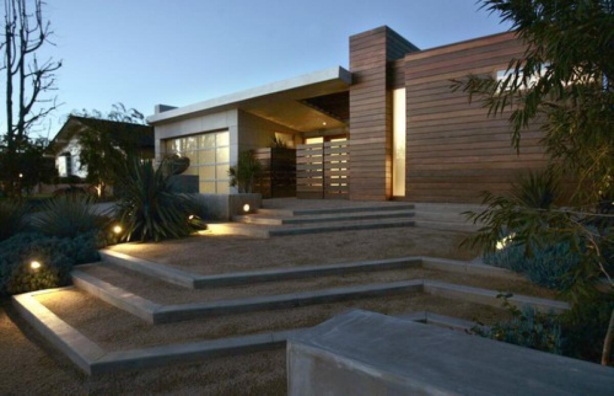 Architect Annette Wiley turned her 1950s tract home in Corona del Mar into a contemporary residence remodeled with environmentally friendly materials and practices. The siding is ipe wood and cement board with recycled content. The steps leading to the entry are decomposed granite.