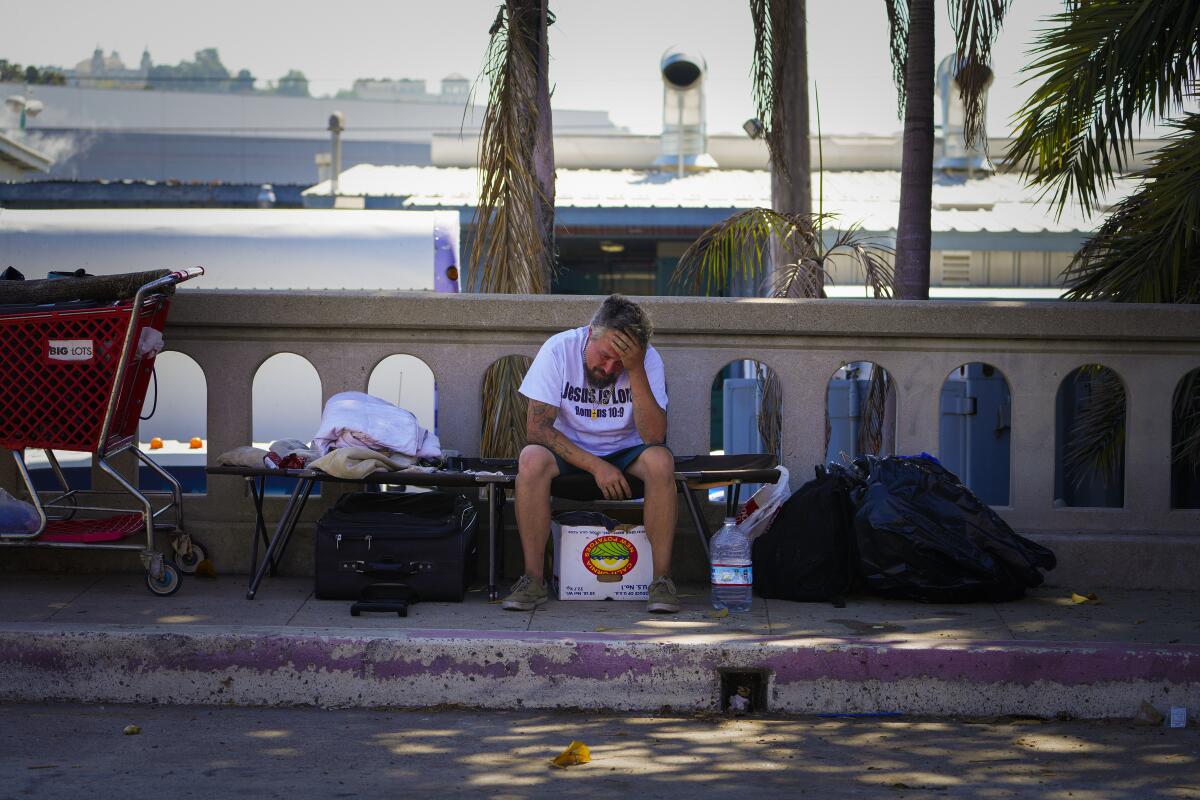 Eric Barbar, 36, sits on a cot where he has been sleeping and living since his van was impounded.