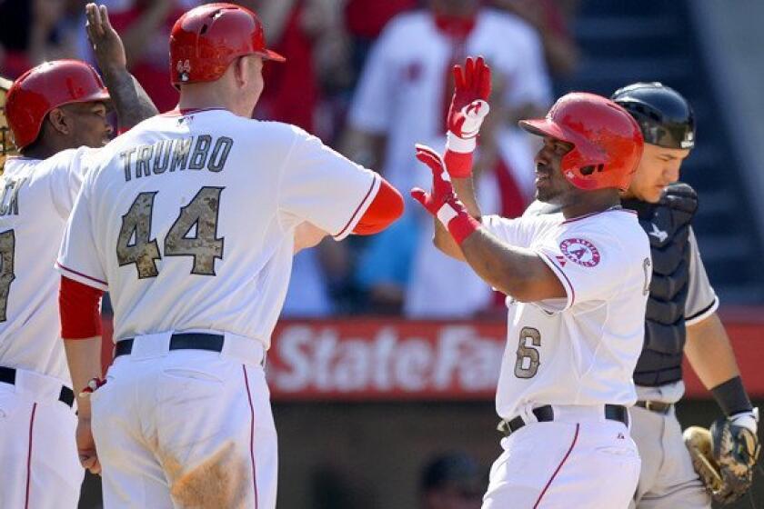 Angels third baseman Alberto Callaspo (6) is congratulated by teammates Mark Trumbo and Howie Kendrick after hitting a three-run home run in the seventh inning against the Chicago White Sox on Saturday.