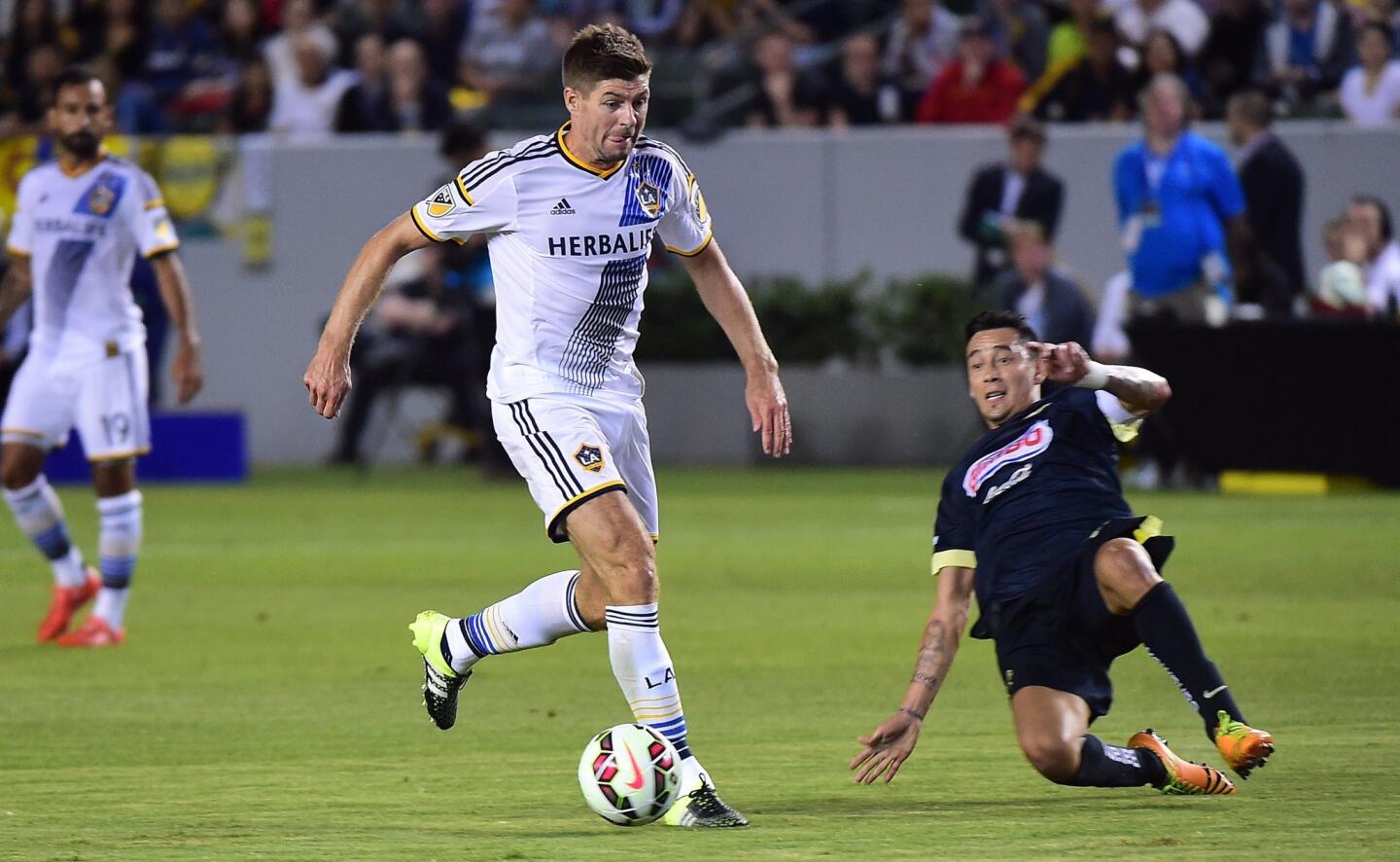 In his MLS debut, Liverpool FC legend Steven Gerrard (C) of the LA Galaxy looks to pass under pressure from Gil Buron of Club America on July 11, 2015 during their 2015 International Champions Cup match in Carson, California. AFP PHOTO / FREDERIC J. BROWNFREDERIC J. BROWN/AFP/Getty Images ** OUTS - ELSENT, FPG - OUTS * NM, PH, VA if sourced by CT, LA or MoD **
