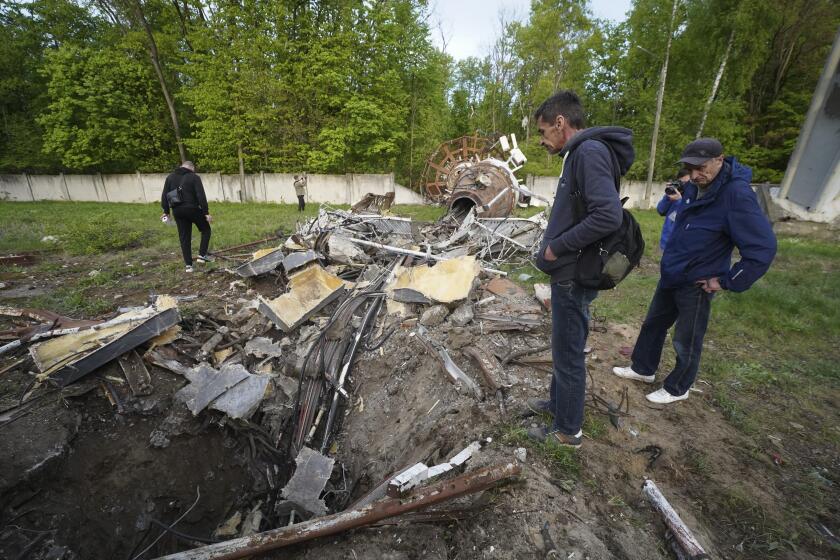 People look at fragments of the television tower which was broken in half after it was hit by a Russian missile in Kharkiv, Ukraine, Monday, April 22, 2024. (AP Photo/Andrii Marienko)