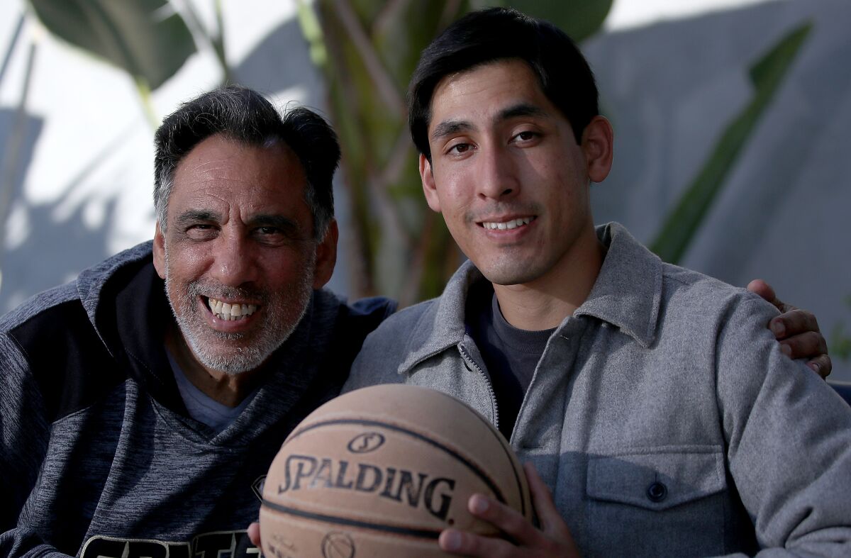 Marcus Droz and his father, Manuel pose together in a portrait.