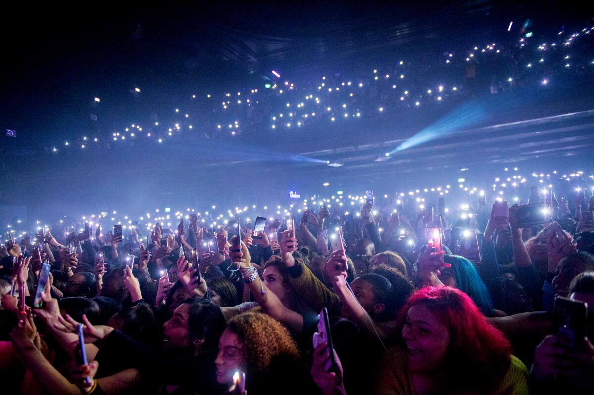 A concert audience holding their cellphones aloft.
