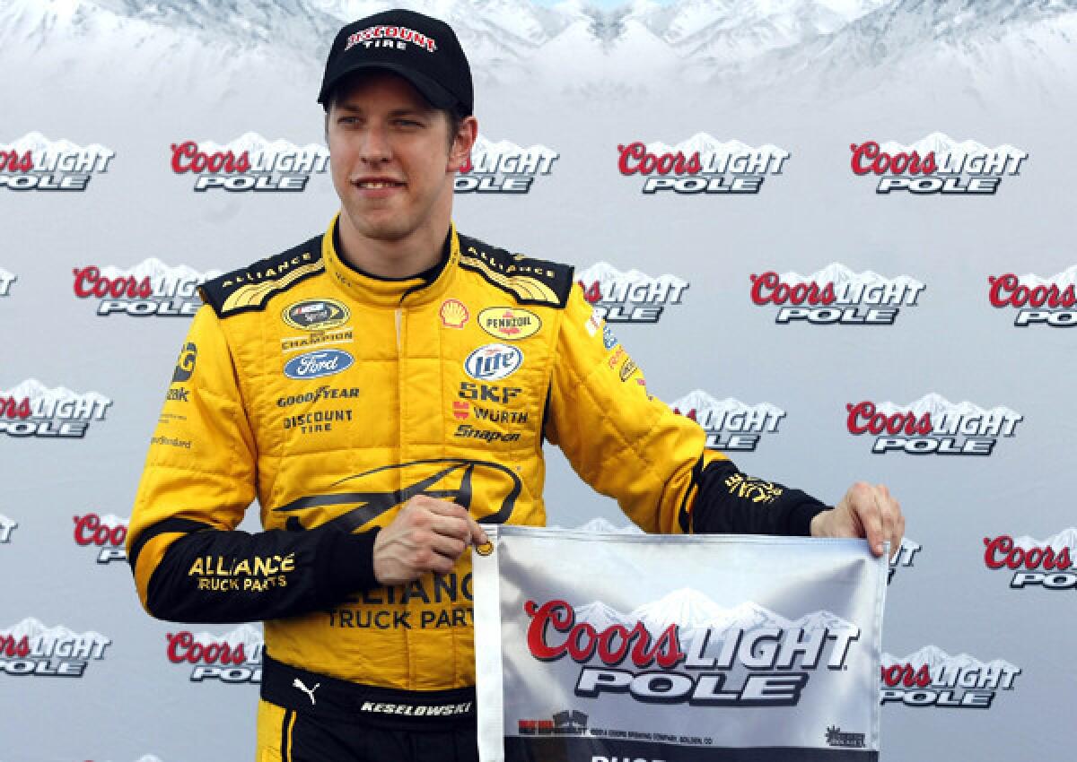 Brad Keselowski holds the victor's flag after winning the pole for Sunday's NASCAR Sprint Cup Series race.