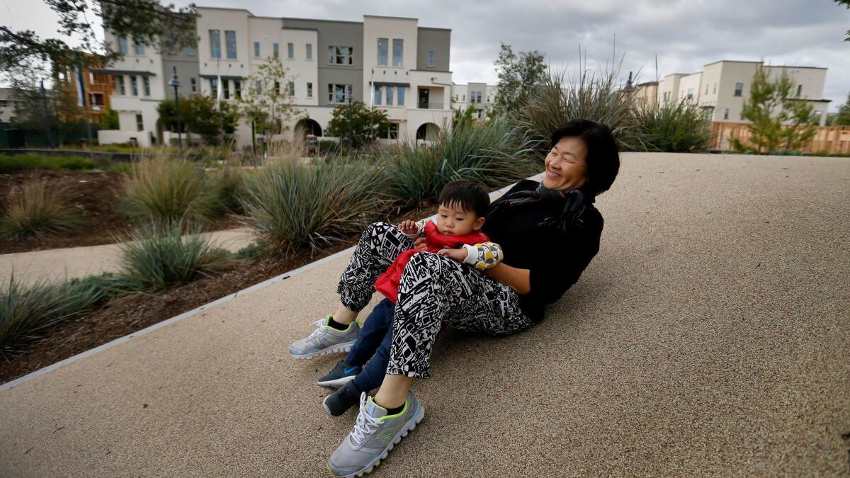 Doris Han, 60, plays with grandson Aaron at Beacon Park. She treasures their time together in a place she described as having "so much peace and with lots of not good English speakers, like me." (Allen J. Schaben / Los Angeles Times)
